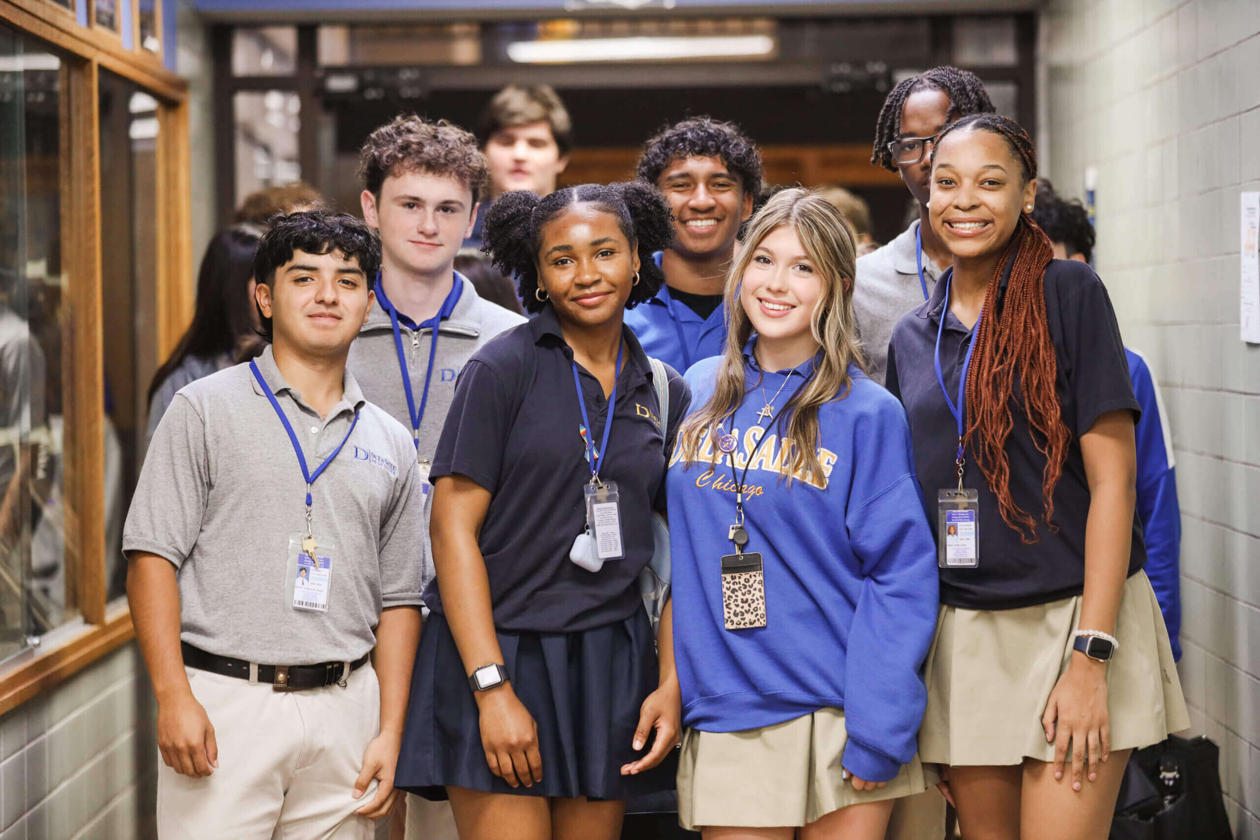 Group of students smiling in a hallway.
